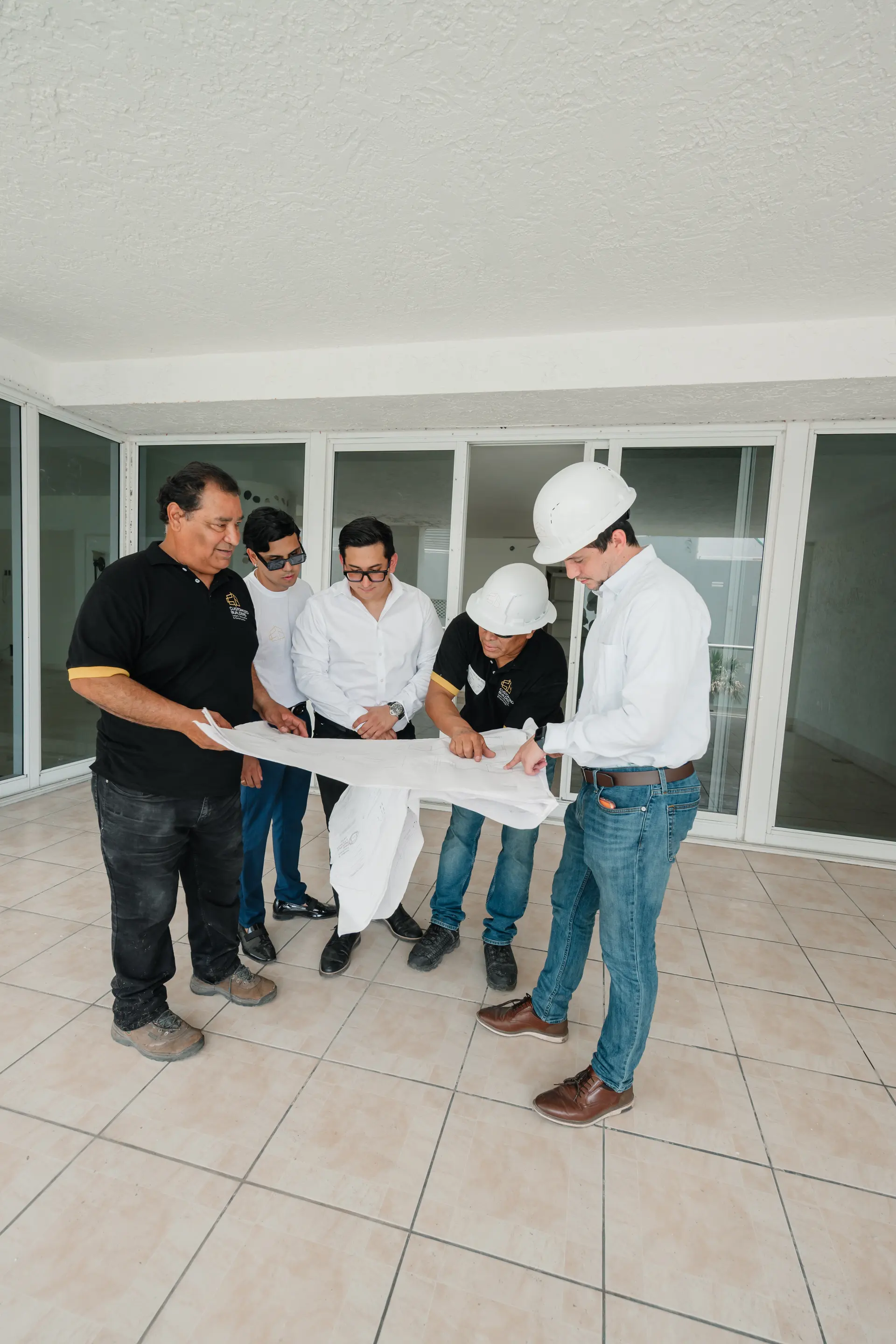 Customized Builders team reviewing architectural plans on site